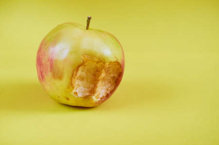A bitten Apple lies on a colored background. Close upの写真素材