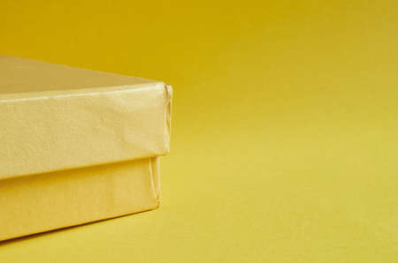 Edge of a yellow cardboard box on a yellow backgroundの写真素材