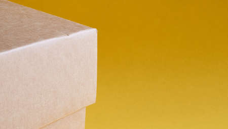 Corner of a brown cardboard box close up on a yellow backgroundの写真素材