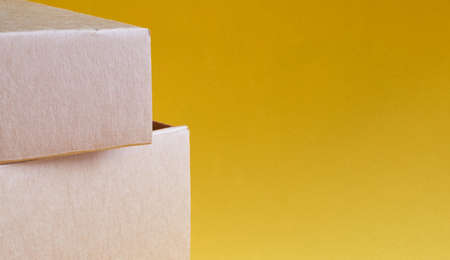 Corner of a brown cardboard box close up on a yellow backgroundの写真素材