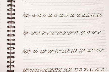 Page of a school notebook with handwritten letters of the English alphabet in close-up