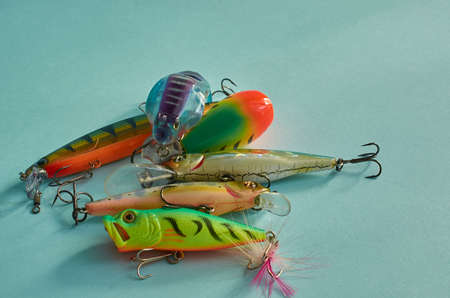 Fishing equipment. Six multi-colored plastic fishing wobblers close-up on a blue background