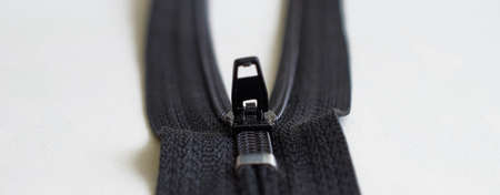 Sewing supplies. Black zipper close-up on a gray background. Banner