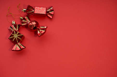 Christmas layout. Three red Christmas toys in the form of candy on a red background. Space for text.