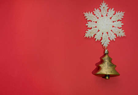 Christmas layout. Snowflake and Christmas tree toy on a red background. Space for text