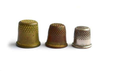 Three vintage thimbles stand in a row isolated on a white background.の写真素材