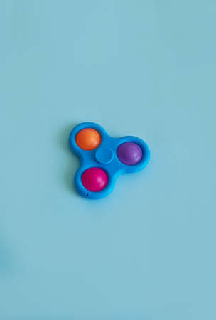 Silicone Toy Spinner Simple Dimple. Blue background. Vertical format. Copy spaceの写真素材