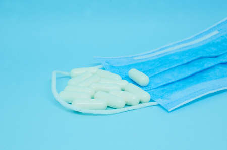 White capsules and a medical mask. Copy spaceの写真素材