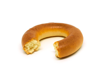 A bitten bagel isolated on a white background, close up