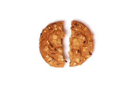 Homemade cakes. Round oatmeal cookies with cereals and seeds broken in half isolated on a white backgroundの写真素材