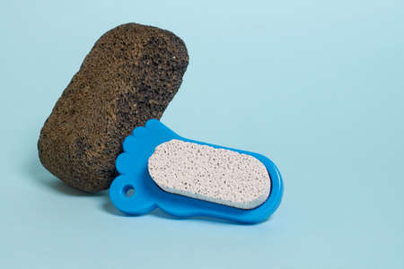 Pedicure accessories. Black pumice stone on a blue backgroundの写真素材