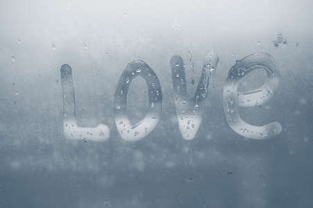 The word LOVE written on the fogged glassの写真素材