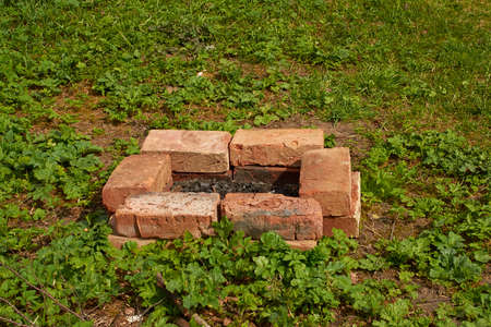 Rectangular fire pit, fenced with red brick, on the lawnの写真素材