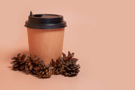 mockup. A paper cup of coffee and a pine cones on a colored background. Horizontal format, copy spaceの写真素材