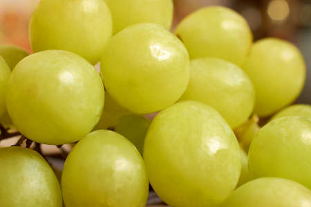 Background of green grapes in close-up. Selective focus, horizontal format, macro