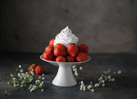 Fresh strawberries with whipped cream, frozen yogurt on a dark backgroundの写真素材