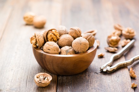 Walnuts in wooden bowl on table with Nutcracker.の写真素材