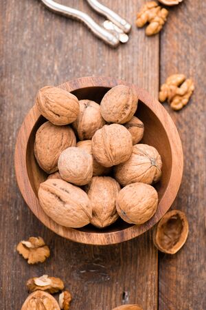 Walnuts in wooden bowl on table with Nutcracker. Top view.の写真素材