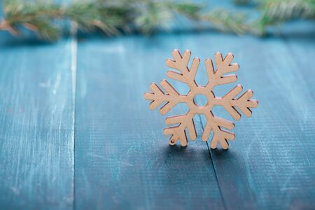 Unpainted wooden snowflake on a blue table. Christmas decoration. Copy space.の写真素材