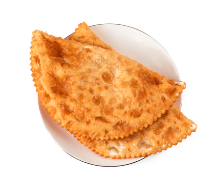 Two Chebureks on white plate isolated with clipping path. Top view. Pasties.の写真素材