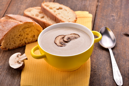 Mushroom cream soup on yellow napkin. Wooden table. Copyspace.の写真素材
