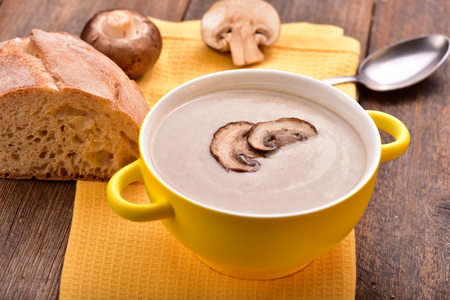 Mushroom cream soup on yellow napkin. Wooden table. Copyspace.の写真素材