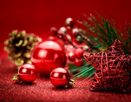 Christmas holiday concept. Red Christmas balls with star and Christmas branch tree on red background. Bokeh.の写真素材