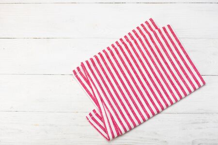 Red rustic napkin isolated on white wooden table. Copy space. Top view.の写真素材