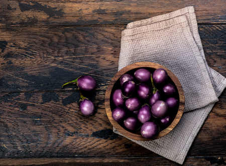 Colorful mini-eggplants on rustic wooden board. Organic raw baby Indian eggplants in a bowl. Top view.の写真素材