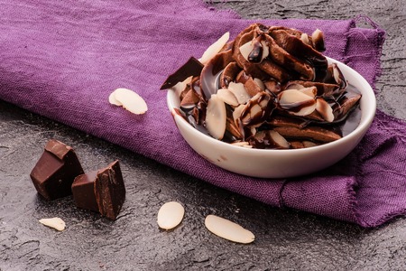 Chocolate mousse with chocolate sauce and chocolate pieces, almond slices in a glasses on a vintage background.の写真素材