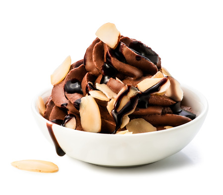 Bowl of chocolate whipped cream with slices of almond isolated on white background by clipping path. Macro.の写真素材