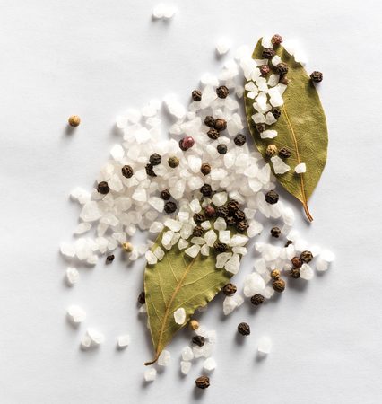Salt and mix of pepper with bay leaves on white background. Top view.の写真素材