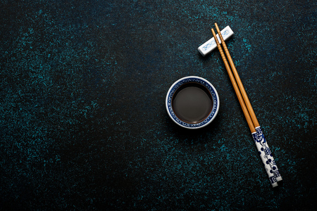 Japanese sushi chopsticks and soy sauce bowl on blue dark stone backgroundの写真素材