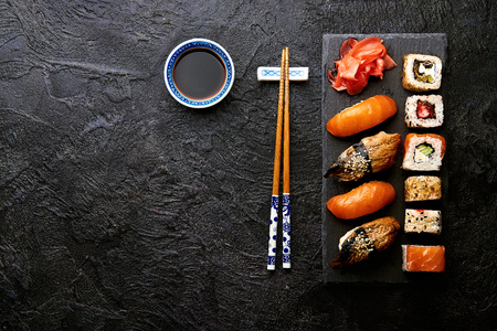 Variation of sushi and rolls on stone table. Sushi rolls, sashimi set with chopsticks. Top view with copy space.の写真素材