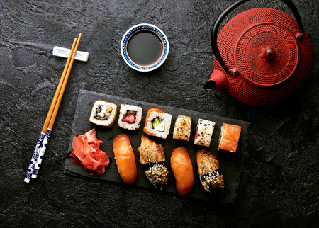 Variation of sushi and rolls on stone table. Sushi rolls, sashimi set with chopsticks. Top view with copy space.の写真素材