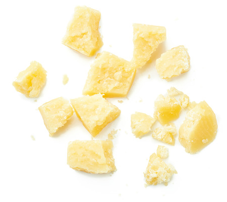 Parmesan cheese pieces on white background. Italian cheese slices. Top view.の写真素材