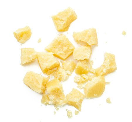 Parmesan cheese pieces on white background. Italian cheese slices. Top view.の写真素材