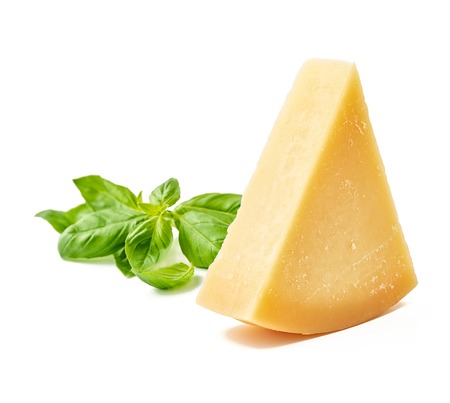 Parmesan cheese with basil leaves on white background. Italian cheese slices.の写真素材