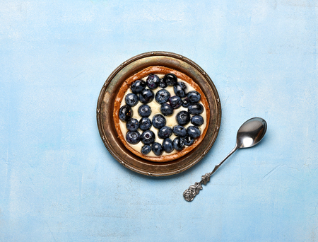 Blueberry tart, pie, tartlet with custard on blue stone background.の写真素材