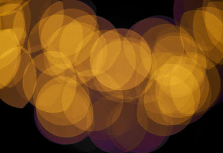 Orange circles bokeh on black background.の写真素材