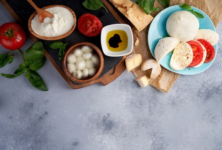 Italian cheeses. Mozzarella Buffalo, crottin, balls, Stracciatella, basil leaves, tomatoes, olive...