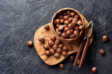 Hazelnut with nutcracker on olive wooden board. Copy space for text. Top view.の写真素材