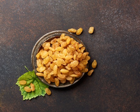 Heap of yellow raisins on the plate with copy space. Top view of dried grapes.の写真素材