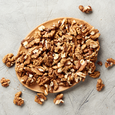 Walnut kernels on gray background and nutcracker.の写真素材