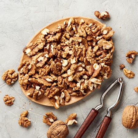 Walnut kernels on gray background and nutcracker.の写真素材