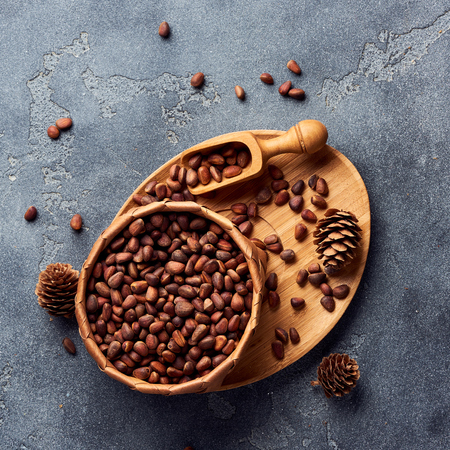 Pine nuts in bowl on gray stone table. Top view.の写真素材