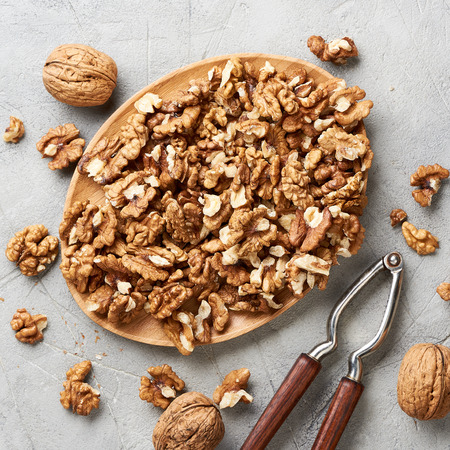 Walnut kernels on gray background and nutcracker.の写真素材