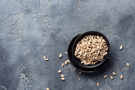 Peeled sunflower seeds on gray concrete background with copy space. Top view.の写真素材