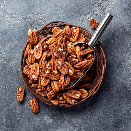 Pecan nuts and scoop on gray tableの写真素材