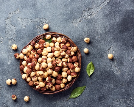 Hazelnuts and green leaves on gray backgroundの写真素材
